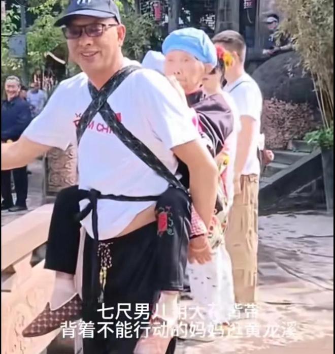 男子背九旬妈妈旅游，被人民日报点赞，男子的身份曝出，感动网友